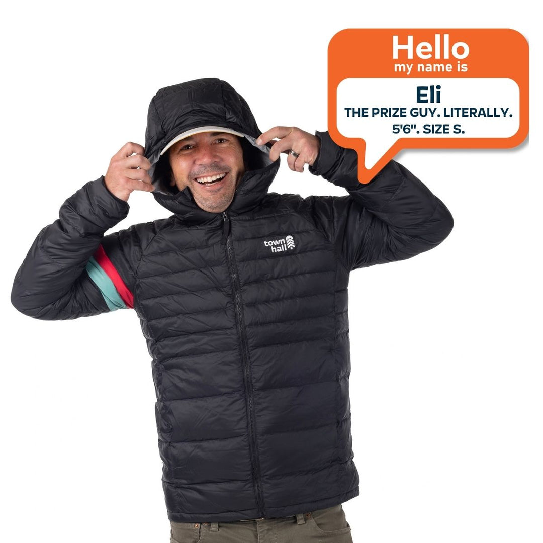 Eli, 5 feet 6 inches tall, wearing a size small Town Hall Adult Down Town Puffy black down jacket.