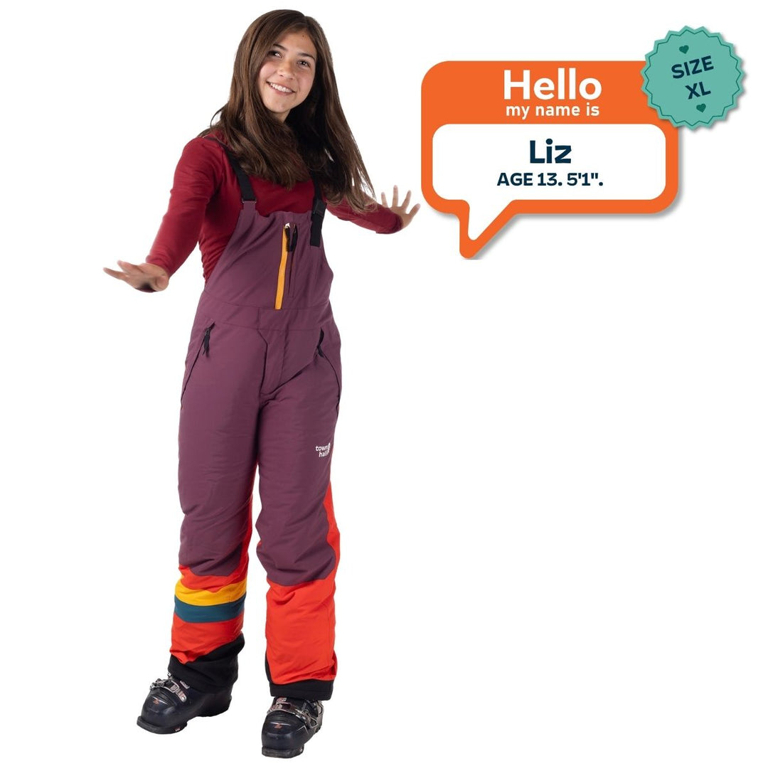 Liz, age 13 and 5 feet 1 inch tall, wearing a size XL Mountain Town kids snow bib in Grape Jam purple and orange.